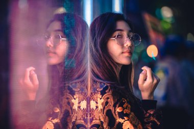Açık havada, arka plan bulanık neon ışıkları ile poz güzel karışık ırk kadın