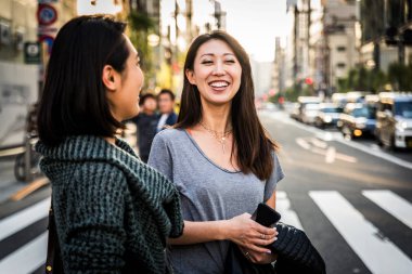 Açık havada toplantı ve having fun - Japon halkı Tokyo sokaklarında bağ iki kız arkadaşım