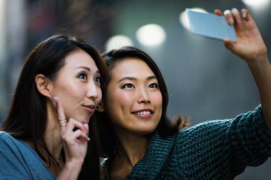 Açık havada toplantı ve having fun - Japon halkı Tokyo sokaklarında bağ iki kız arkadaşım
