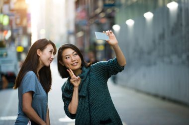 Açık havada toplantı ve having fun - Japon halkı Tokyo sokaklarında bağ iki kız arkadaşım