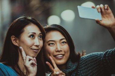 Açık havada toplantı ve having fun - Japon halkı Tokyo sokaklarında bağ iki kız arkadaşım