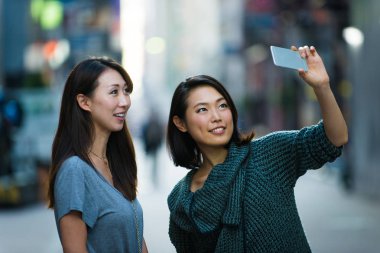 Açık havada toplantı ve having fun - Japon halkı Tokyo sokaklarında bağ iki kız arkadaşım