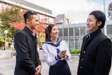 Yung Japon öğrenciler okul üniforması ile açık havada - Asya genç eğleniyor grup yapıştırma