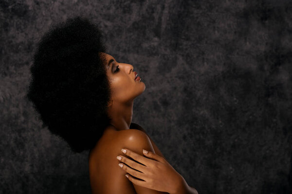 Portrait of pretty afro american woman in a studio for a beauty session - Beautiful girl posing on colored background