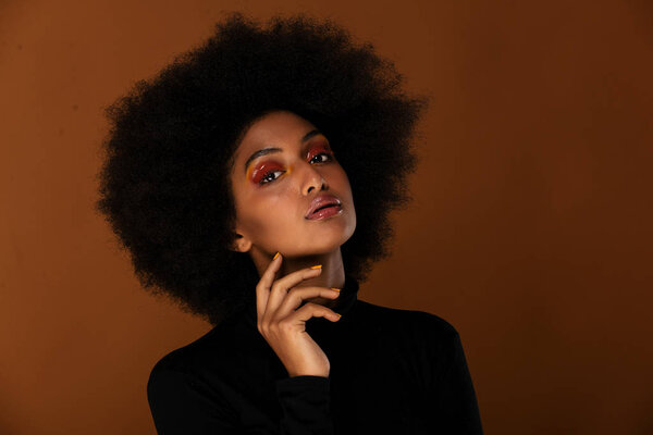 Portrait of pretty afro american woman in a studio for a beauty session - Beautiful girl posing on colored background