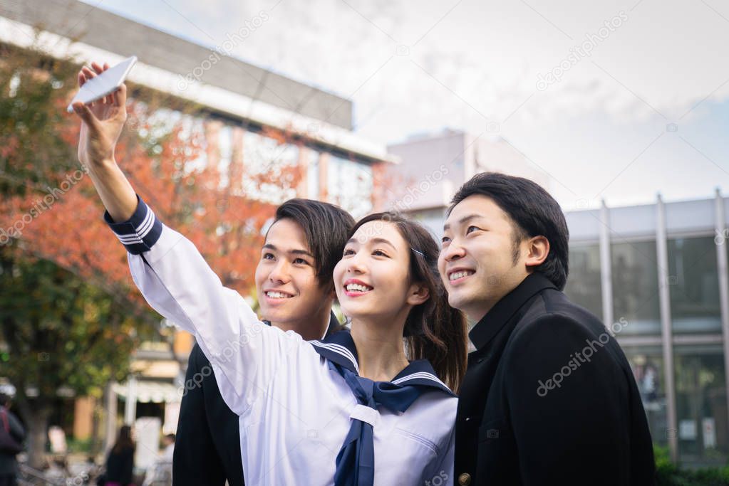 Yung japanese students with school uniform bonding outdoors - Group of asian teenagers having fun
