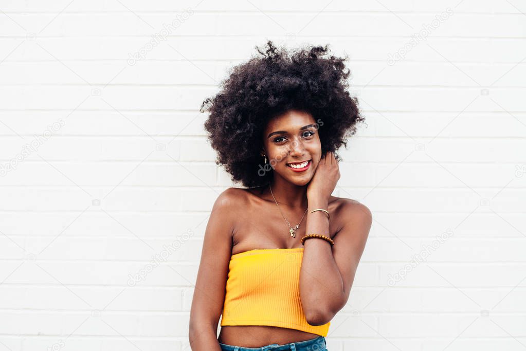 Beautiful american girl posing against a white wall in New york