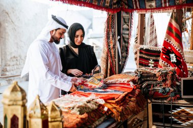 Mutlu çift Dubai'de zaman harcama. erkek ve kadın geleneksel kıyafetlerle eski şehirde alışveriş yapma