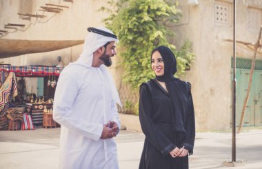 Mutlu çift Dubai'de zaman harcama. erkek ve kadın geleneksel kıyafetlerle eski şehirde alışveriş yapma