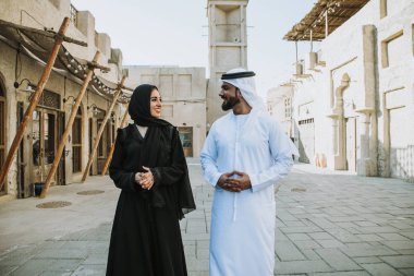 Mutlu çift Dubai'de zaman harcama. erkek ve kadın geleneksel kıyafetlerle eski şehirde alışveriş yapma
