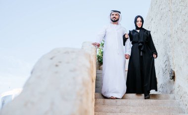 Mutlu çift Dubai'de zaman harcama. erkek ve kadın geleneksel kıyafetlerle eski şehirde alışveriş yapma