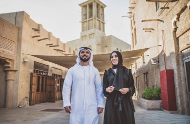 Mutlu çift Dubai'de zaman harcama. erkek ve kadın geleneksel kıyafetlerle eski şehirde alışveriş yapma