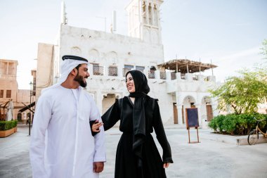 Mutlu çift Dubai'de zaman harcama. erkek ve kadın geleneksel kıyafetlerle eski şehirde alışveriş yapma