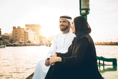 Mutlu çift Dubai'de zaman harcama. Nehrin üzerinde bir seyir alarak geleneksel kıyafetlerle kadın ve erkek