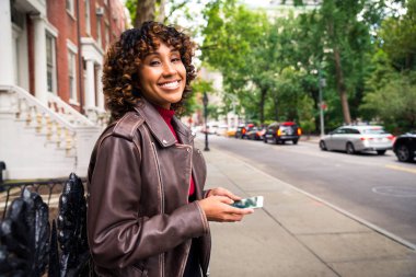 Happy african american woman smiling. Beautiful young femal walking and having fun in New York city clipart