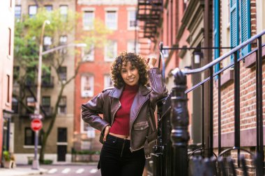 Gülümseyerek mutlu bir Afrikalı-Amerikalı kadın. Güzel genç kadın yürüyüş ve New York'ta eğleniyor