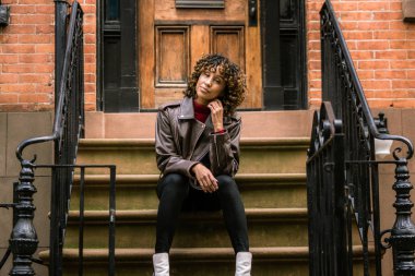 Gülümseyerek mutlu bir Afrikalı-Amerikalı kadın. Güzel genç kadın yürüyüş ve New York'ta eğleniyor