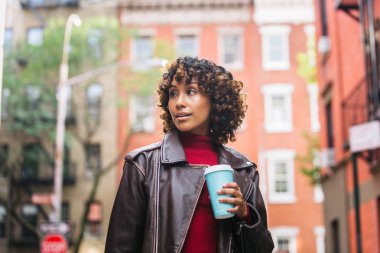 Gülümseyerek mutlu bir Afrikalı-Amerikalı kadın. Güzel genç kadın yürüyüş ve New York'ta eğleniyor