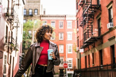 Gülümseyerek mutlu bir Afrikalı-Amerikalı kadın. Güzel genç kadın yürüyüş ve New York'ta eğleniyor