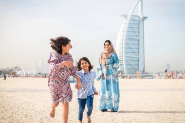 Dubai - anne kızı sahilde birlikte eğleniyor mutlu Arap aile