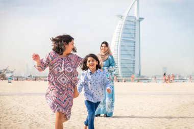 Dubai - anne kızı sahilde birlikte eğleniyor mutlu Arap aile