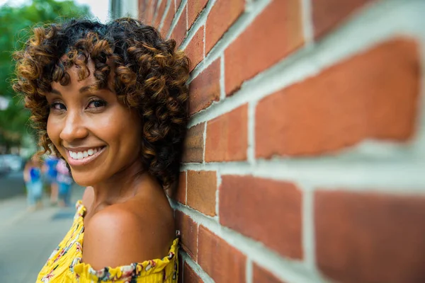 Gülümseyerek mutlu bir Afrikalı-Amerikalı kadın. Güzel genç kadın yürüyüş ve New York'ta eğleniyor