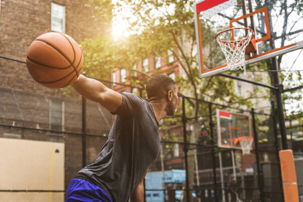 Afro-american basketball player training on a court in New York - Sportive man playing basket outdoors