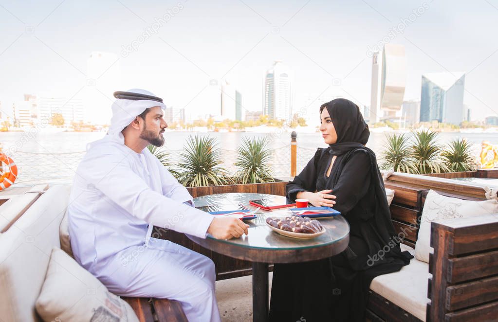 Arabian couple with traditional emirates dress dating outdoors - Happy middle-eastern couple having fun