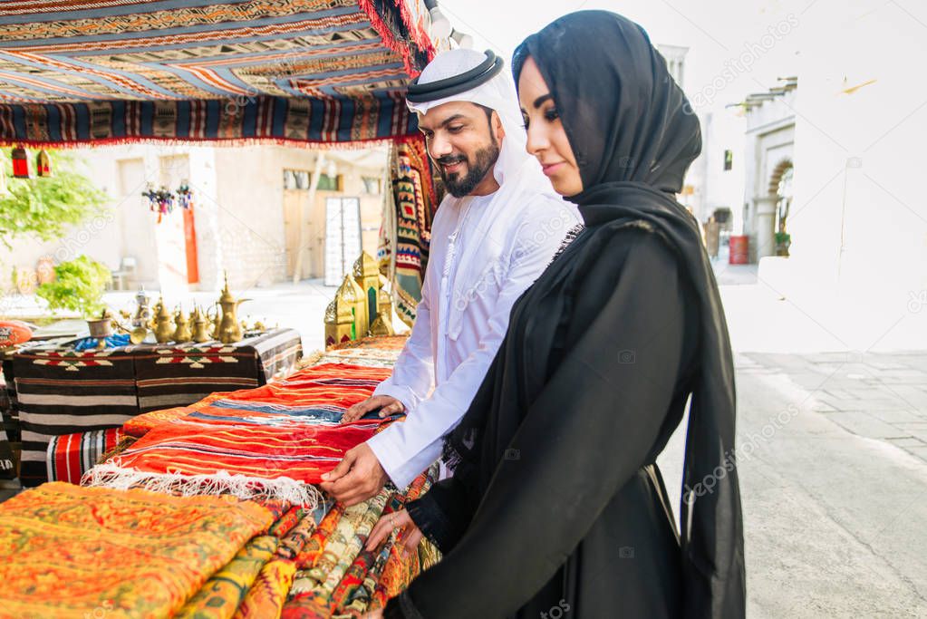 Arabian couple with traditional emirates dress dating outdoors - Happy middle-eastern couple having fun