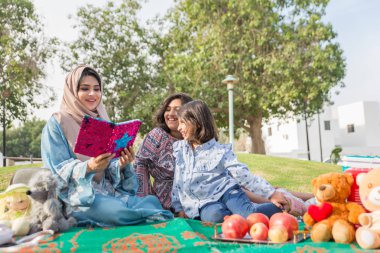 Dubai - anne kızları bir parkta birlikte eğleniyor mutlu Arap aile