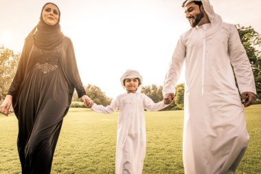 Dubai - ebeveynler ve çocuklar hafta sonu doğada kutluyor bir parkta eğleniyor mutlu bir Orta Doğulu aile