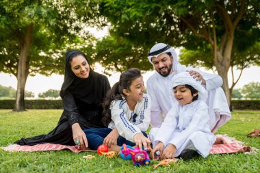 Dubai - ebeveynler ve çocuklar hafta sonu doğada kutluyor bir parkta eğleniyor mutlu bir Orta Doğulu aile