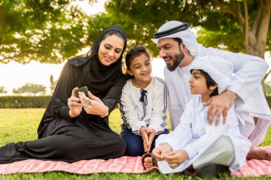 Dubai - ebeveynler ve çocuklar hafta sonu doğada kutluyor bir parkta eğleniyor mutlu bir Orta Doğulu aile