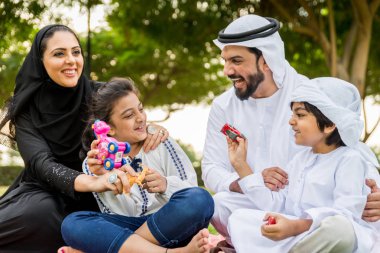 Dubai - ebeveynler ve çocuklar hafta sonu doğada kutluyor bir parkta eğleniyor mutlu bir Orta Doğulu aile