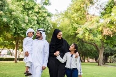 Dubai - ebeveynler ve çocuklar hafta sonu doğada kutluyor bir parkta eğleniyor mutlu bir Orta Doğulu aile