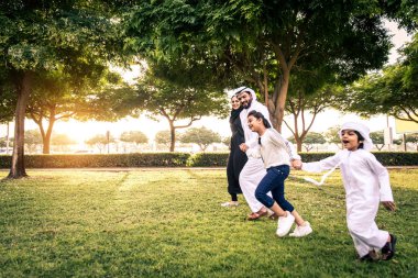 Dubai - ebeveynler ve çocuklar hafta sonu doğada kutluyor bir parkta eğleniyor mutlu bir Orta Doğulu aile