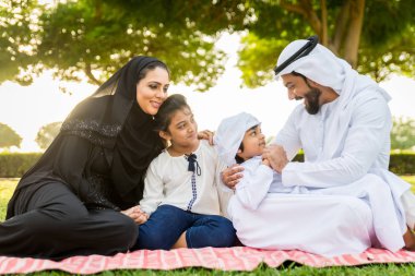 Dubai - ebeveynler ve çocuklar hafta sonu doğada kutluyor bir parkta eğleniyor mutlu bir Orta Doğulu aile