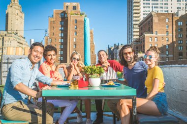 Mutlu gençler New York - parti ve eğlenerek arkadaş grubu bir çatıda bir barbekü akşam yemeği
