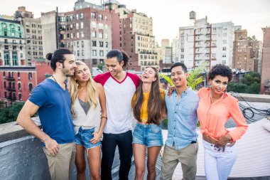 Mutlu gençler New York - parti ve eğlenerek arkadaş grubu bir çatıda bir barbekü akşam yemeği
