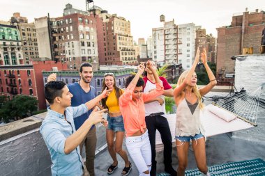 Mutlu gençler New York - parti ve eğlenerek arkadaş grubu bir çatıda bir barbekü akşam yemeği