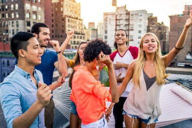 Mutlu gençler New York - parti ve eğlenerek arkadaş grubu bir çatıda bir barbekü akşam yemeği