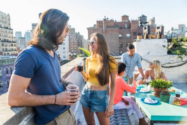 Mutlu gençler New York - parti ve eğlenerek arkadaş grubu bir çatıda bir barbekü akşam yemeği