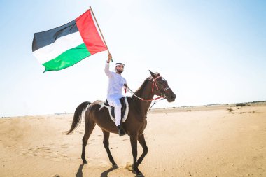 Yakışıklı adamla Orta Doğu: Dubai çölünde Arapça bir binicilik tipik Emirlikleri elbise