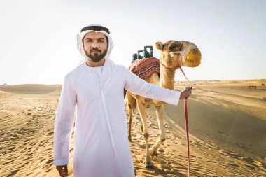 Kandura ve gatra bir deve çölde sürme ile Orta Doğu yakışıklı