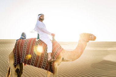 Kandura ve gatra bir deve çölde sürme ile Orta Doğu yakışıklı