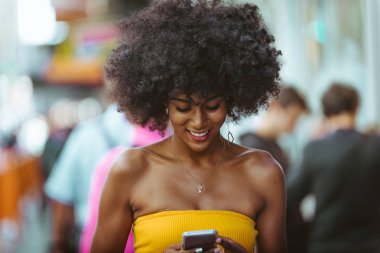 Gülümseyerek mutlu bir Afrikalı-Amerikalı kadın. Yürüyüş ve New York'ta eğleniyor güzel genç kadın