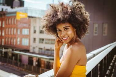Gülümseyerek mutlu bir Afrikalı-Amerikalı kadın. Yürüyüş ve New York'ta eğleniyor güzel genç kadın