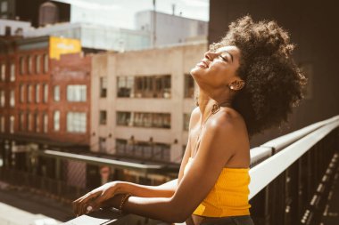 Gülümseyerek mutlu bir Afrikalı-Amerikalı kadın. Yürüyüş ve New York'ta eğleniyor güzel genç kadın