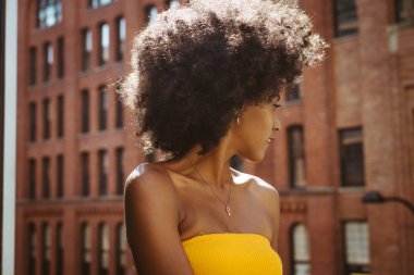 Gülümseyerek mutlu bir Afrikalı-Amerikalı kadın. Yürüyüş ve New York'ta eğleniyor güzel genç kadın