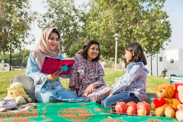 Dubai - anne kızları bir parkta birlikte eğleniyor mutlu Arap aile